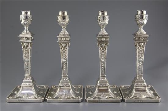 Two pairs of George III silver Adam style candlesticks, weighted.